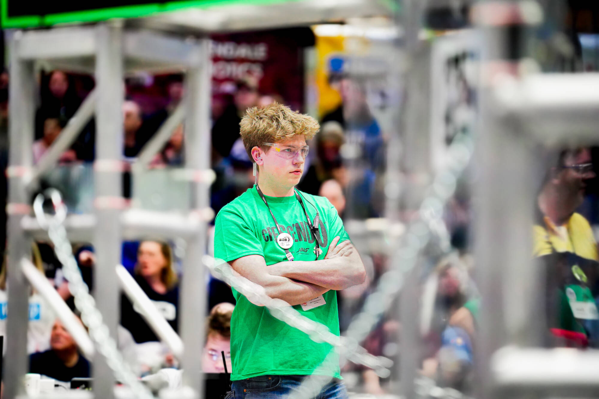 A robotics competitor in a green t-shirts watches the 2026 FIM District West Michigan Event